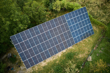 Aerial view of solar panels in green field at daytime. Different types of ground-mounted photovoltaic systems. Concept of ecological energy. Photo-voltaic collection of modules as a PV panel.