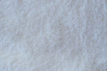 Soft beige knitted fabric as background, closeup. Fluffy fabric for the whole picture