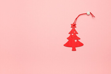 Christmas wooden tree on pink background. Composition of a postcard with free space for text. The concept of New Year and Christmas.