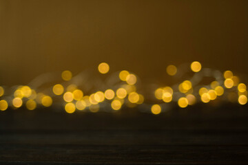Background with wooden texture and golden bokeh in the background. Selective focus of horizontal surface