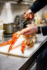 Close up hand of chef in restaurant cut the crab leg
