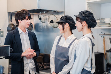 レストランのオーナーと話をするスタッフ