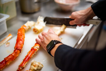Close up hand of chef in restaurant cut the crab leg