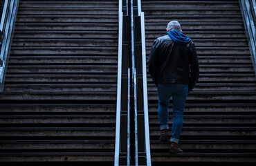 Rear view of adult man going upstairs