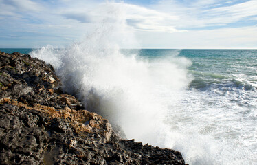 Wave crashing against rocks. Wave splashing.