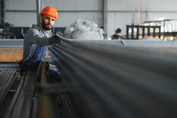 Factory worker measures the metal profile