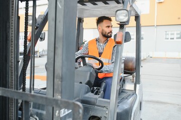 Waving forklift driver in the warehouse of a haulage company while driving forklift