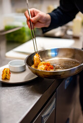 man chef cooking tasty shrimp on kitchen