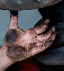 Mechanic's hand covered with oil.