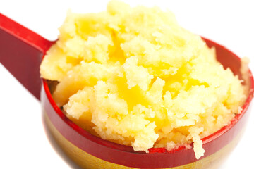 Ghee in wooden spoon isolated on white background