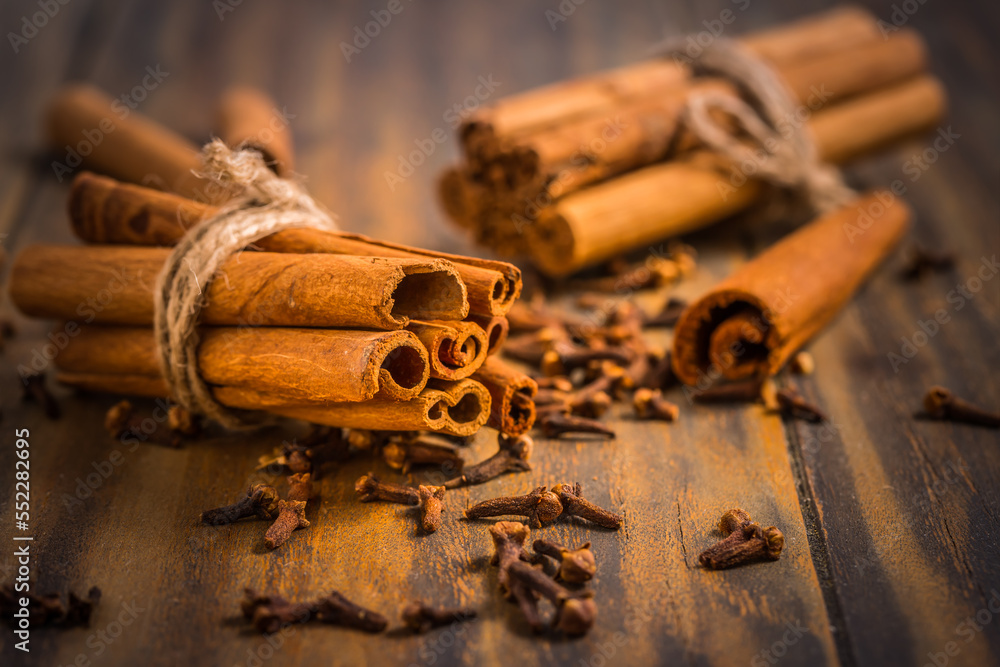 Wall mural christmas spices and baking ingredients: cinnamon sticks and cloves on wooden kitchen table