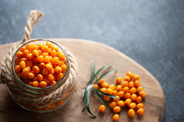 Sea buckthorn berries in a jar, orange healthy berries, macro