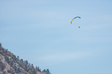 single paraglider on blue sky near a high mountain
