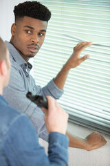 man stands nearby a blinders talking to someone