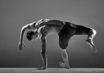 Black and white footage of male flexible muscular athlete showing animal flow sport elements...