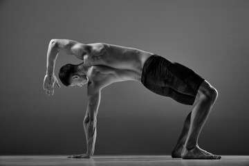 Black and white footage of male flexible muscular athlete showing animal flow sport elements...