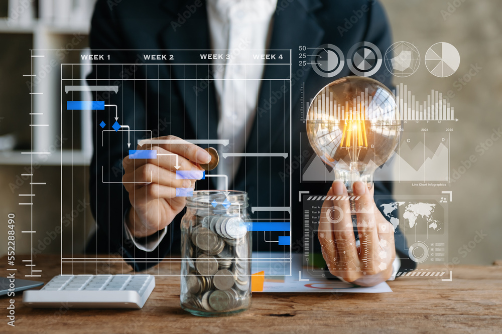 Poster business hand holding lightbulb with using laptop computer and money stack in office. idea saving en