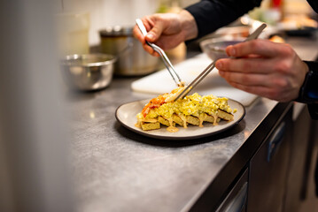 chef cooking brioche with scrambled eggs, caviar and crab meat on kitchen