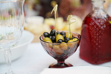 a bowl of green and black olives on the dining room table. 