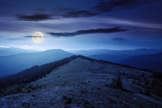 scenic chornohora ridge landscape in summer at night. beautiful scenery of carpathian mountains with coniferous trees and alpine meadows in full moon light. travel ukraine