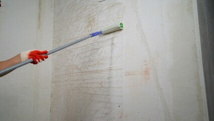 The process of applying a primer to a wall using a roller. The primer solution is applied to the...