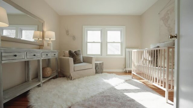push in shot of a nursery with a lounge chair and baby crib