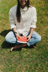 Girl Reading and Walking on Grass, Phone
