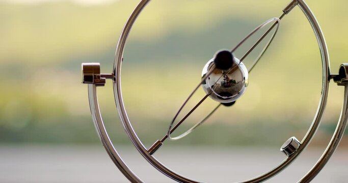 Rotating table pendulum balls anti stress in the tropical nature background at the morning, video for meditation, pendulum with rotating balls. Perpetual motion machine. Eternal movement