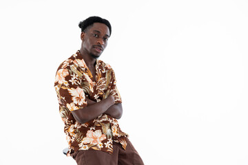 Portrait of fashionable good-looked african american man looking at camera with funny hairstyle sitting on chair on white background in studio isolated.