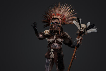 Portrait of aboriginal witch dressed in ceremonial attire and plumed headdress.