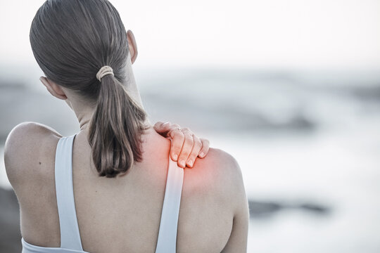 Back, pain and injury with a sports woman holding her shoulder during an exercise workout on the beach. Fitness, health and wellness with a digital CGI or overlay on a female hand outdoor in nature