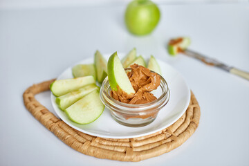 Green slices apples with peanut butter on white background, healthy snack, nutrition food, diet