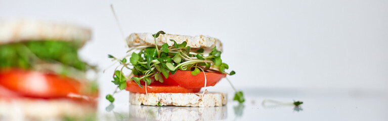 Banner  Healthy burger with crispy rice bread vegetables tomato and microgreens on white...