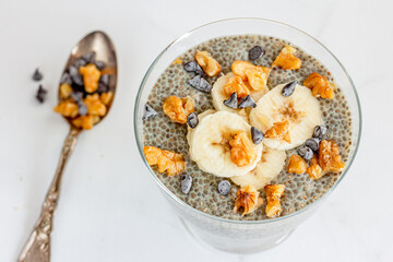 Healthy Chia Pudding with Banana, Nuts and Chocolate Chips Top Down Close-Up Photo