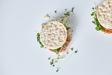 Top view Healthy burger with crispy rice bread vegetables tomato and microgreens on white...