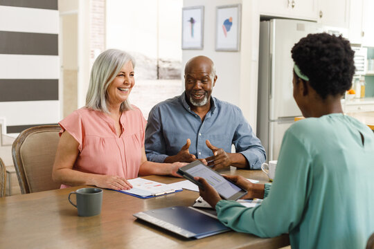 Senior diverse couple talking with african american female financial advisor