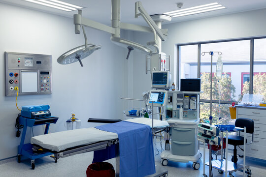 Medical equipment, technology and lighting over operating table in empty hospital operating theatre