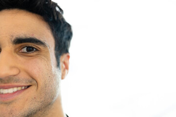 Obraz premium Half face portrait of smiling biracial male doctor, with copy space