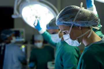 Caucasian female surgical tech and colleague adjusting lights in operating theatre, with copy space