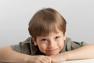 Portrait of a surprised child in good mood close-up isolated on white background. Cute little boy looking at camera. Caucasian appearance. Beautiful light-skinned preschooler kid. Photo for documents.