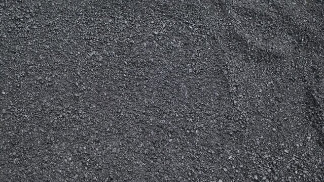 The road construction crew used shovels and mops to level the asphalt for a new coating.