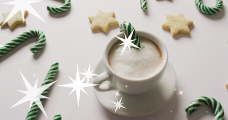 Animation of snow falling over christmas drink and decorations