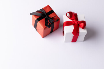 White and red gifts with red and black ribbons, on white background with copy space