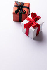 Vertical of white and red gifts with red and black ribbons, on white background with copy space