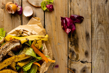 Overhead of organic fruit and vegetable food waste spilling from full kitchen composting bin