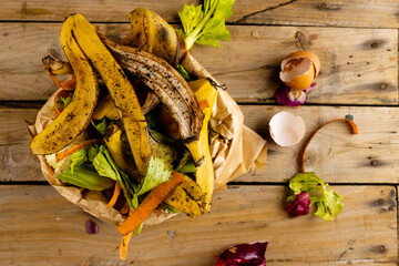 Overhead of organic fruit and vegetable food waste spilling from full kitchen composting bin