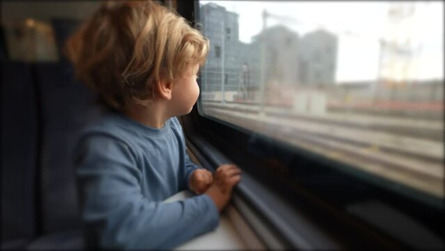 One little boy traveling by train looking out window