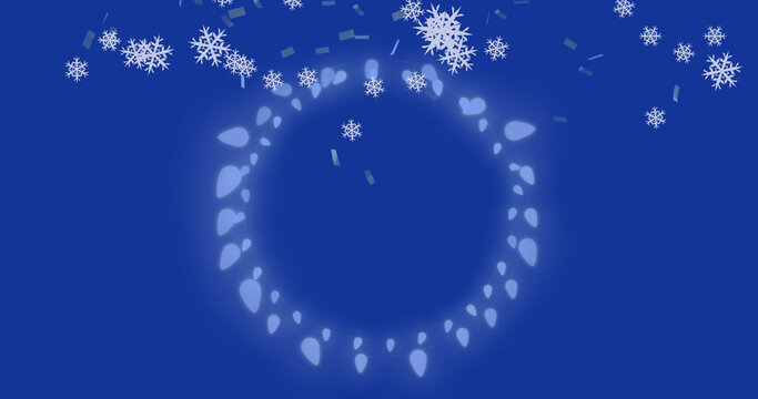 Image of snowflakes over christmas lights on blue background