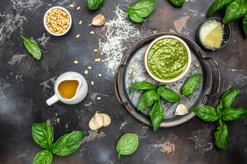 Obraz na płótnie Canvas Green basil pesto with italian recipe ingredients, Basil, olive oil, parmesan, garlic, pine nuts. banner, menu, recipe place for text, top view