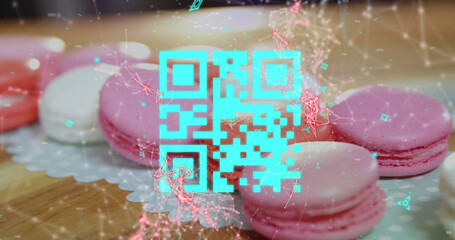 Blue QR code with a red floating web of connections over pink macaronies lying on a table